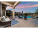 Covered patio with wicker furniture overlooking a sparkling pool and desert landscape at 1641 N Channing --, Mesa, AZ 85207