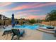 Inviting pool area with umbrellas, lounge chairs, and lush landscaping at sunset at 1641 N Channing --, Mesa, AZ 85207