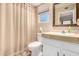 Bathroom with a single sink vanity, a mirror, and a toilet with a shower and curtain at 1703 Leisure World --, Mesa, AZ 85206