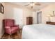 Cozy bedroom with wood floors, a ceiling fan, an accent chair, and natural light at 1703 Leisure World --, Mesa, AZ 85206