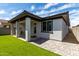 Backyard showing a covered patio, artificial turf, and modern exterior with a window at 17437 W Via De Luna Dr, Surprise, AZ 85387