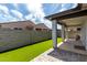 Backyard view showing covered patio, artificial turf, and a block fence providing privacy at 17437 W Via De Luna Dr, Surprise, AZ 85387