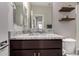 Bathroom featuring granite counters, dark wood cabinets, decorative shelves, and modern fixtures at 17437 W Via De Luna Dr, Surprise, AZ 85387