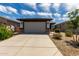 Home exterior featuring a two car garage with a neutral door and stone accents at 17437 W Via De Luna Dr, Surprise, AZ 85387