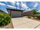 Home exterior featuring a two car garage and manicured landscaping at 17437 W Via De Luna Dr, Surprise, AZ 85387
