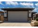 Home exterior showcasing a two-car garage with a modern design and stone accents at 17437 W Via De Luna Dr, Surprise, AZ 85387