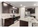 Beautiful kitchen features granite counters, stainless steel appliances, and dark wood cabinets at 17437 W Via De Luna Dr, Surprise, AZ 85387