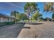 Large backyard with mature trees providing shade, a grassy area, and views of neighboring properties at 17668 N Del Webb Blvd, Sun City, AZ 85373