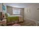 Cozy bedroom featuring a bed with a light green quilt, soft carpet, and natural light from the window at 17668 N Del Webb Blvd, Sun City, AZ 85373