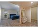 Spacious bedroom with a blue quilted bed, white wicker furniture, and an ensuite bathroom through an entry at 17668 N Del Webb Blvd, Sun City, AZ 85373