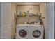 Functional laundry room featuring a side-by-side washer and dryer and overhead shelving for storage at 17668 N Del Webb Blvd, Sun City, AZ 85373