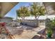 Inviting outdoor patio with stone flooring, a dining set, lush trees, and privacy walls at 17668 N Del Webb Blvd, Sun City, AZ 85373