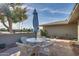 Outdoor patio features a round glass table with seating for four under an umbrella, great for entertaining at 17668 N Del Webb Blvd, Sun City, AZ 85373