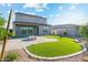 Backyard featuring a fire pit, green turf, desert landscaping and home exterior at 17831 W Mission Ln, Waddell, AZ 85355