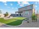 Backyard featuring a fire pit, green turf, desert landscaping and home exterior at 17831 W Mission Ln, Waddell, AZ 85355