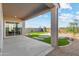 A covered back patio overlooks a lush backyard with artificial turf and a paver patio with a fire pit at 17831 W Mission Ln, Waddell, AZ 85355