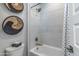 Shower and tub combo with white tile and decorative wall baskets at 17831 W Mission Ln, Waddell, AZ 85355