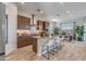 The kitchen features an island with seating, stainless steel appliances, modern cabinetry, and wood-look tile flooring at 17831 W Mission Ln, Waddell, AZ 85355