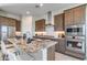 The kitchen has a large island with seating, modern stainless steel appliances, and stylish countertops at 17831 W Mission Ln, Waddell, AZ 85355