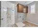 Functional laundry room with overhead cabinets, connections for appliances, and tile flooring at 17831 W Mission Ln, Waddell, AZ 85355