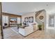 Cozy living room with a large white sofa, decorative rug, and a wall-mounted TV at 17831 W Mission Ln, Waddell, AZ 85355