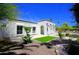 White house with contrasting trim, desert landscaping, and a small lawn, showcasing its curb appeal at 1806 W Rosewood Ct, Chandler, AZ 85224