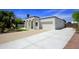 Expansive driveway and garage showcasing the white home's architecture and functional space at 1806 W Rosewood Ct, Chandler, AZ 85224