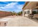 Spacious back patio with seating area surrounded by a low brick wall and neatly landscaped with stones and plants at 18131 W Addie Ln, Surprise, AZ 85374