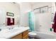 Bright bathroom featuring a clean white sink and a bathtub with a decorative shower curtain at 18131 W Addie Ln, Surprise, AZ 85374