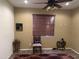 Comfortable bedroom with neutral walls, brown blinds, ceiling fan, and tile floors at 18131 W Addie Ln, Surprise, AZ 85374