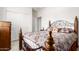 Well-lit bedroom with decorative metal bed frame, matching wooden dresser, and a double-door closet at 18131 W Addie Ln, Surprise, AZ 85374