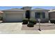 Charming single-story home with a well-manicured front yard, a two car garage, and desert landscaping at 18131 W Addie Ln, Surprise, AZ 85374