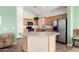 Kitchen with center island, stainless steel refrigerator, and light wood cabinetry at 18131 W Addie Ln, Surprise, AZ 85374