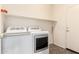 Functional laundry room equipped with a modern washer and dryer set and a convenient upper shelf at 18131 W Addie Ln, Surprise, AZ 85374