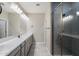 Bright bathroom featuring a double vanity with a modern walk-in shower with glass door at 1823 E Chelsea Ln # 106, Gilbert, AZ 85295
