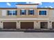 Exterior elevation of brown townhomes with individual garage doors and blue shutters at 1823 E Chelsea Ln # 106, Gilbert, AZ 85295
