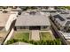 Aerial view of a home's backyard featuring a patio, grass and manicured landscaping at 18929 W Windsor Blvd, Litchfield Park, AZ 85340