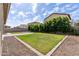 A lovely backyard with a square of green grass surrounded by brick, gravel and greenery at 18929 W Windsor Blvd, Litchfield Park, AZ 85340