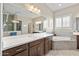 Bright bathroom featuring a double vanity, bathtub, and tiled floors at 18929 W Windsor Blvd, Litchfield Park, AZ 85340