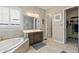 Bright bathroom featuring a tub, walk-in closet, and vanity at 18929 W Windsor Blvd, Litchfield Park, AZ 85340