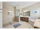 Bright bathroom featuring a walk-in shower, vanity, and soaking tub at 18929 W Windsor Blvd, Litchfield Park, AZ 85340