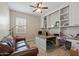 Home office featuring a built-in desk, shelves, and a ceiling fan at 18929 W Windsor Blvd, Litchfield Park, AZ 85340