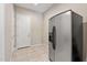 Functional mudroom features tiled flooring and a stainless steel refrigerator, blending practicality with modern convenience at 18929 W Windsor Blvd, Litchfield Park, AZ 85340