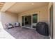 The cozy covered patio features tiled flooring and comfortable seating for relaxing outdoors at 18929 W Windsor Blvd, Litchfield Park, AZ 85340