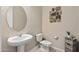 Contemporary powder room with a pedestal sink, modern fixtures, and stylish decor at 18929 W Windsor Blvd, Litchfield Park, AZ 85340