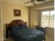 Bedroom with a window bay, ceiling fan, artwork, a wooden headboard, and side tables at 19139 N Alameda Dr, Surprise, AZ 85387