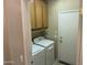 Bright laundry room with a washer, dryer, overhead cabinets, and exterior door at 19139 N Alameda Dr, Surprise, AZ 85387