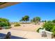 A covered patio overlooks a meticulously landscaped backyard with desert features and manicured bushes at 19892 N Shadow Mountain Dr, Surprise, AZ 85374