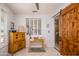 Bright bedroom featuring a desk, a sliding wooden door, shuttered windows, and light-colored walls at 19892 N Shadow Mountain Dr, Surprise, AZ 85374