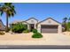 Charming single-story home featuring desert landscaping, a palm tree, and a two-car garage at 19892 N Shadow Mountain Dr, Surprise, AZ 85374